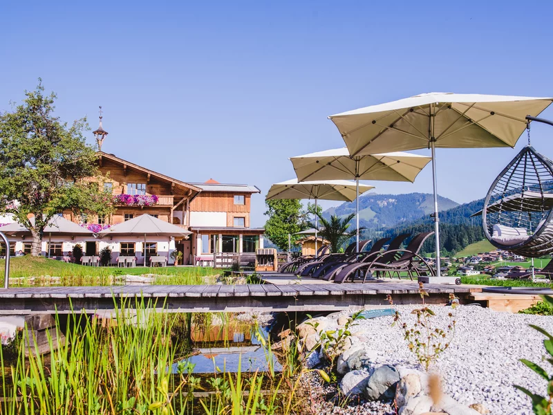 Außenansicht Hotel Sommer mit Schwimmteich im Vordergrund